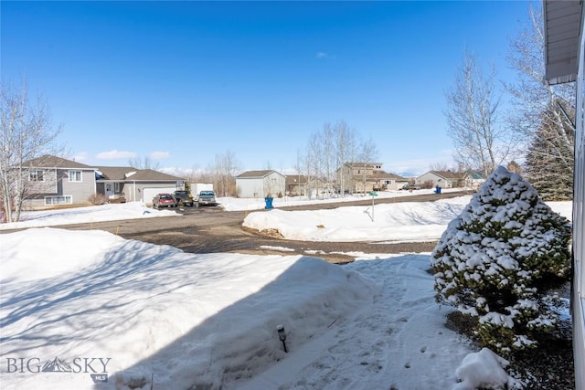 yard layered in snow featuring a residential view