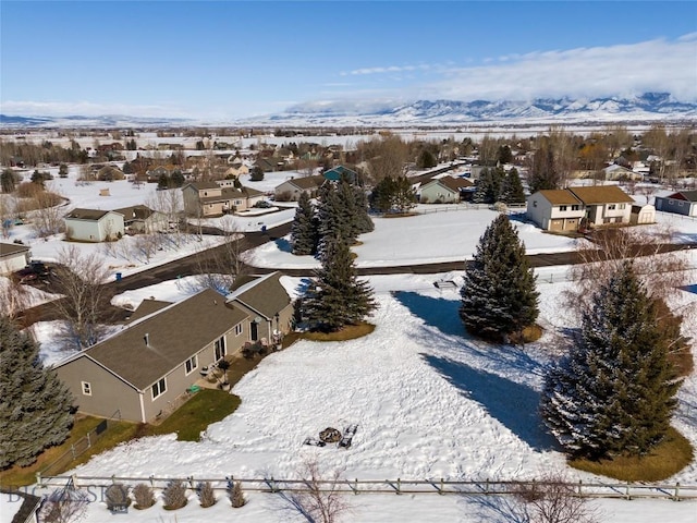 snowy aerial view featuring a residential view and a mountain view