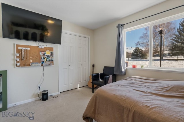 carpeted bedroom with a closet and baseboards