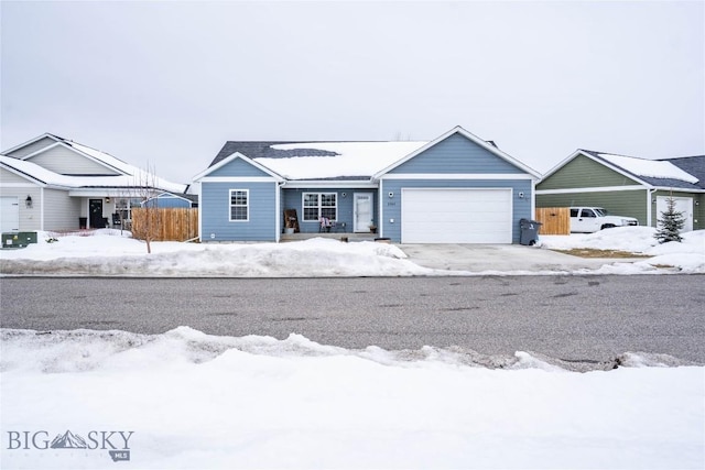 ranch-style home featuring a garage, driveway, and fence