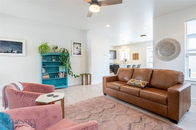 living room with light wood-style floors, ceiling fan, baseboards, and recessed lighting