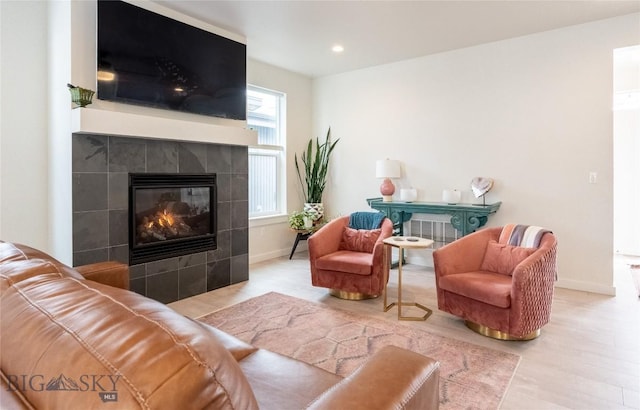 living room featuring recessed lighting, a fireplace, baseboards, and wood finished floors