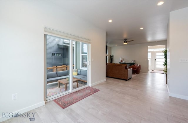 living room featuring baseboards, light wood-type flooring, a ceiling fan, and recessed lighting