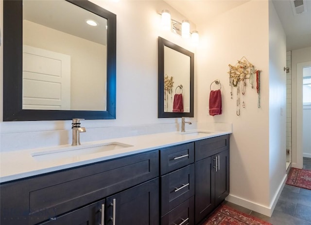 full bath with double vanity, baseboards, visible vents, and a sink