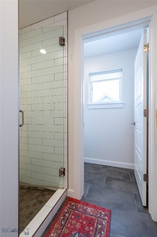 bathroom featuring a shower stall and baseboards