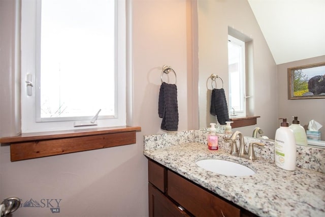 bathroom featuring vaulted ceiling and vanity