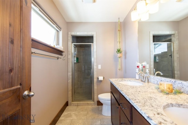 bathroom featuring double vanity, a sink, toilet, and a shower stall