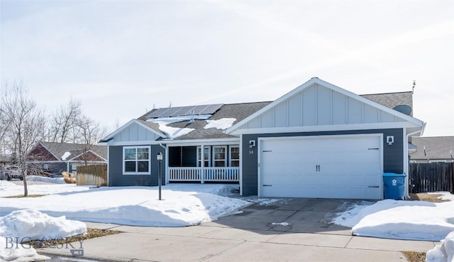 ranch-style house featuring solar panels, concrete driveway, board and batten siding, fence, and a garage