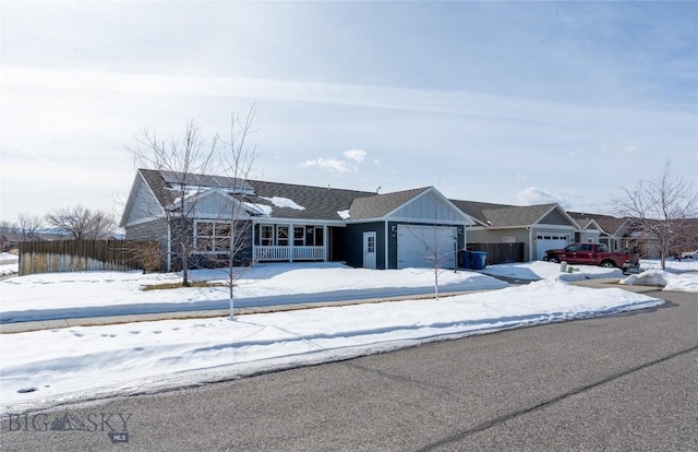 single story home featuring covered porch, board and batten siding, an attached garage, and fence