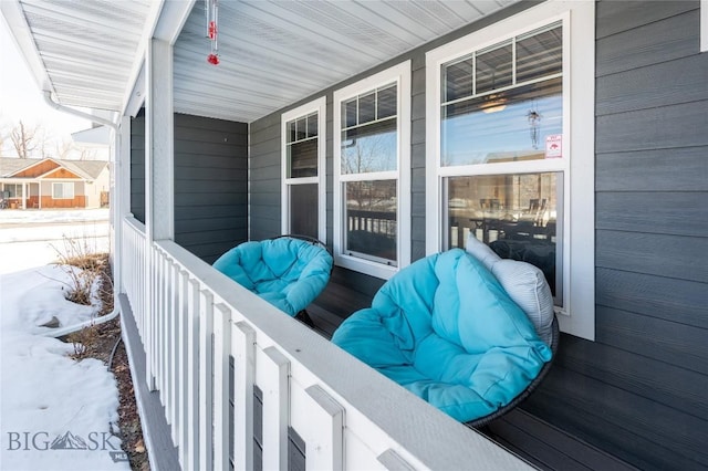 snow covered deck with a porch