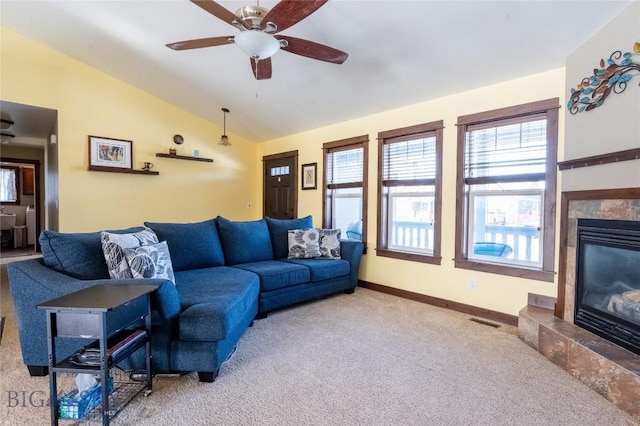 living area featuring visible vents, baseboards, vaulted ceiling, carpet, and a glass covered fireplace