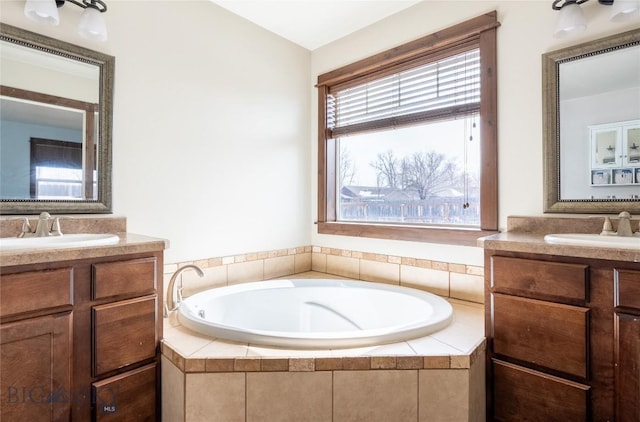 full bathroom with two vanities, a sink, and a bath