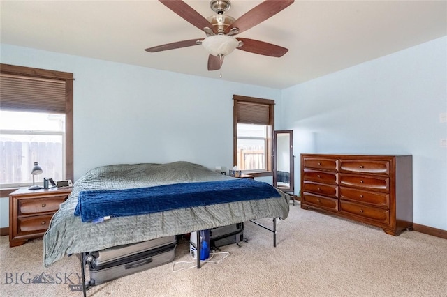 carpeted bedroom with ceiling fan and baseboards