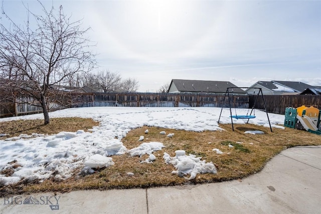 snowy yard with a fenced backyard and a trampoline