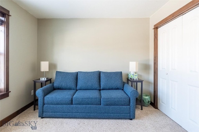 living area with light carpet and baseboards