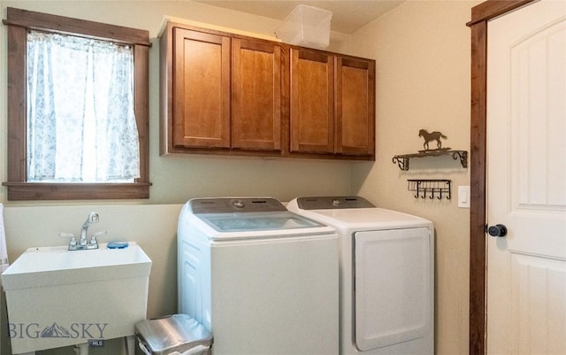 laundry room featuring cabinet space, a sink, and washer and clothes dryer