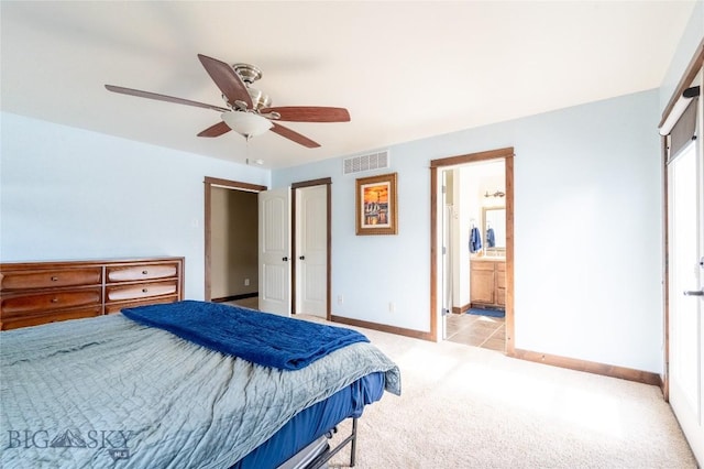 bedroom featuring baseboards, visible vents, a ceiling fan, light colored carpet, and ensuite bath