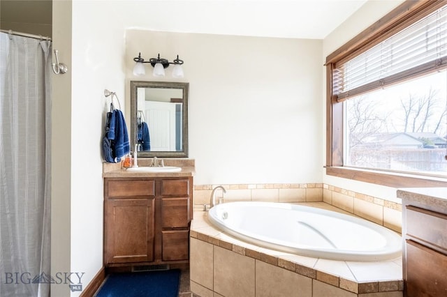 full bath with visible vents, curtained shower, a garden tub, and vanity