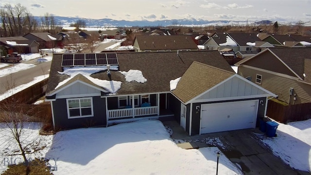 single story home with a porch, a garage, fence, a residential view, and board and batten siding