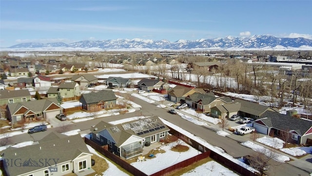 snowy aerial view with a residential view and a mountain view