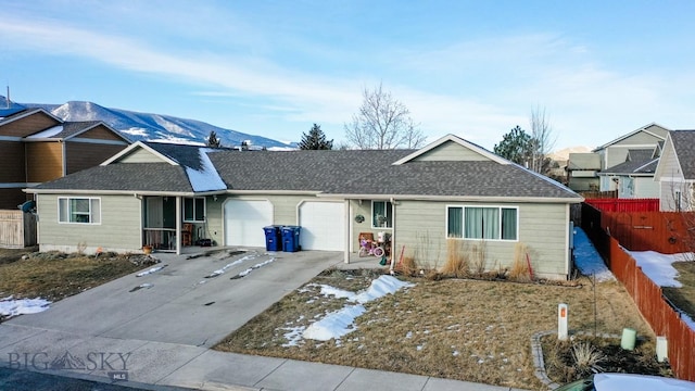 ranch-style home with fence, driveway, roof with shingles, and a garage