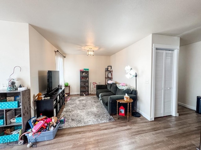 living area featuring baseboards and wood finished floors