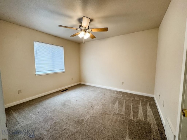carpeted spare room featuring baseboards, a ceiling fan, and visible vents