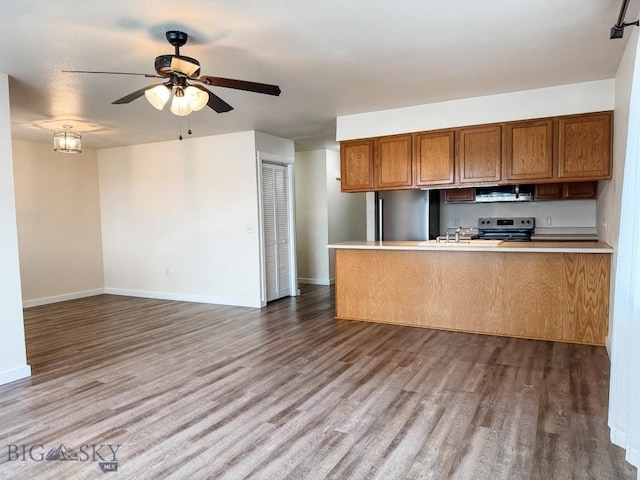 kitchen with wood finished floors, open floor plan, ceiling fan, stainless steel appliances, and baseboards