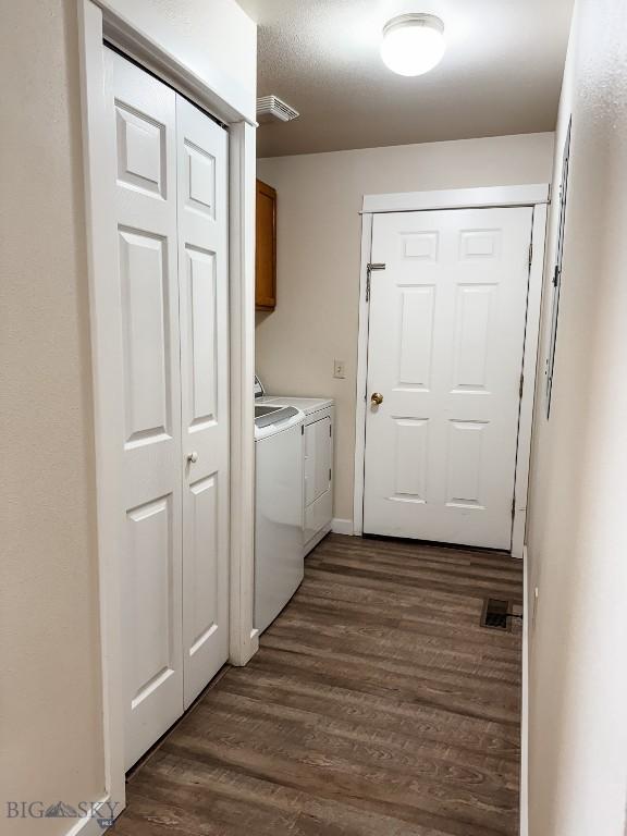 laundry room featuring cabinet space, dark wood finished floors, and separate washer and dryer