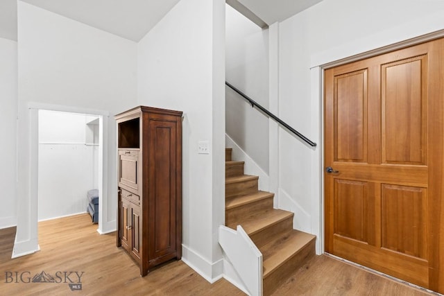 staircase featuring baseboards and wood finished floors