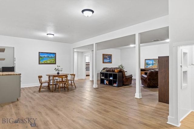 dining area featuring light wood-type flooring, visible vents, and baseboards