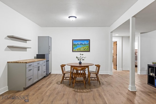 dining room with light wood-style flooring and baseboards