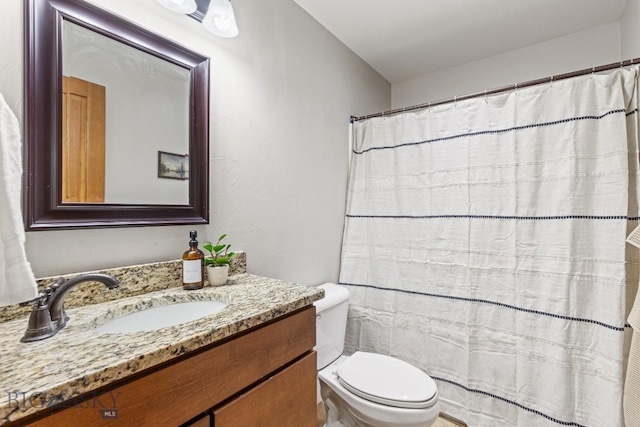 full bathroom with a shower with shower curtain, vanity, and toilet