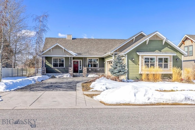 craftsman inspired home featuring covered porch, driveway, a chimney, and fence