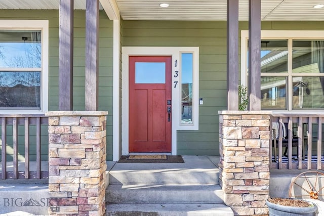 property entrance featuring covered porch and stone siding