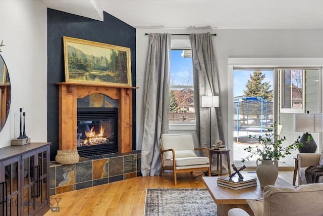 sitting room featuring a tile fireplace and wood finished floors