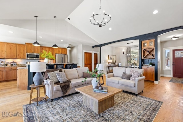 living area featuring an inviting chandelier, light wood-style flooring, arched walkways, and recessed lighting