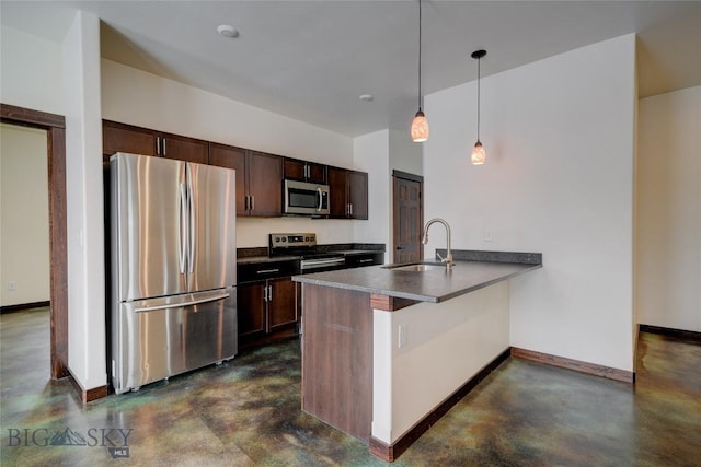 kitchen with dark countertops, a peninsula, finished concrete floors, stainless steel appliances, and a sink