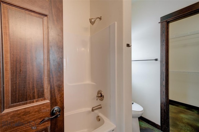 bathroom featuring toilet, baseboards, and shower / bathing tub combination