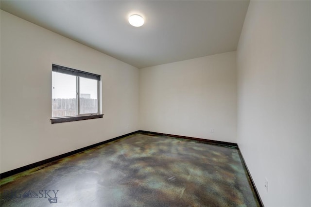 unfurnished room with concrete floors and baseboards