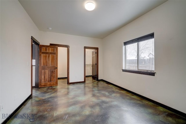 unfurnished bedroom featuring concrete floors and baseboards