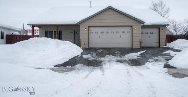 ranch-style home featuring a garage and fence