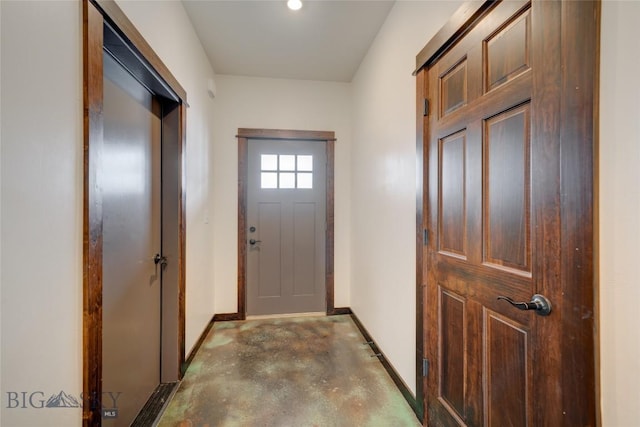 doorway with concrete floors and baseboards