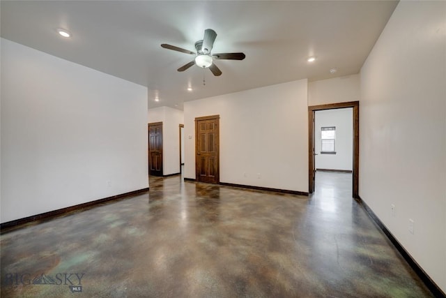 spare room featuring concrete floors, recessed lighting, and baseboards