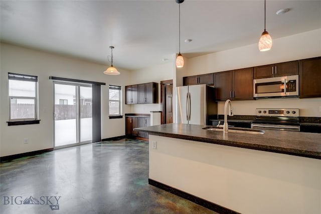 kitchen with dark brown cabinetry, concrete floors, a sink, baseboards, and appliances with stainless steel finishes