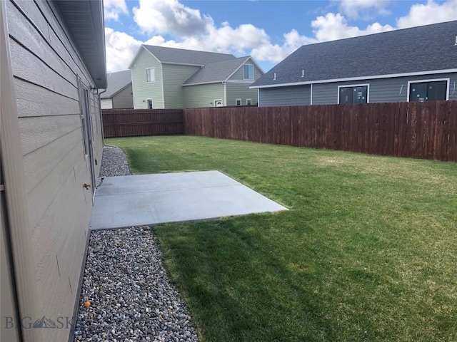 view of yard featuring a residential view, a fenced backyard, and a patio