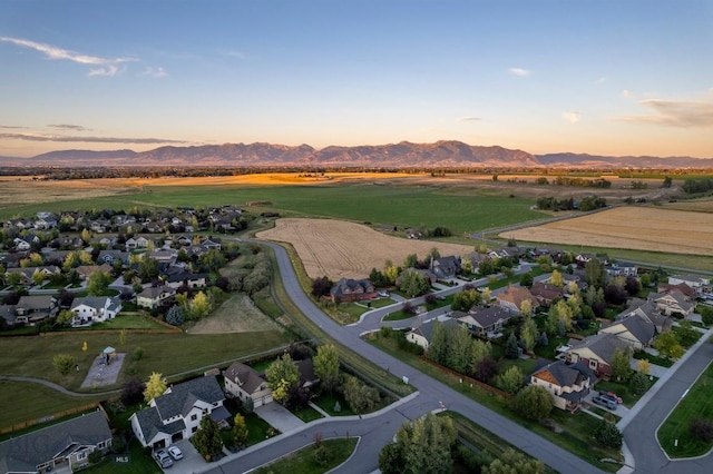 aerial view at dusk featuring a residential view and a mountain view