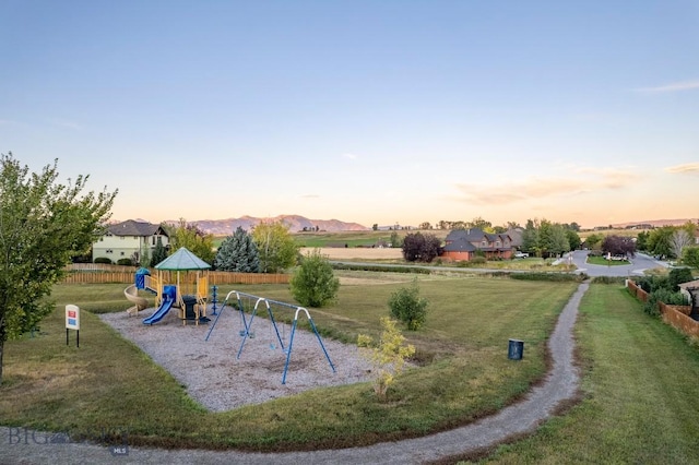 community playground featuring a yard and fence