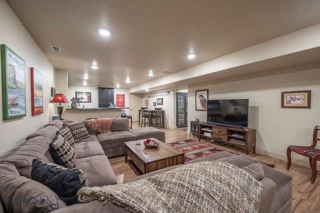 living area with light wood-type flooring, visible vents, and recessed lighting