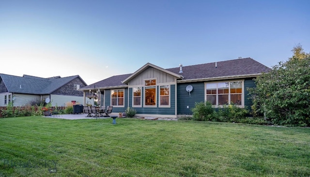 back of property with a patio, board and batten siding, and a lawn